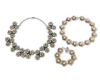309
A Group Of Mexican Silver Jewelry
Mid-20th century
Two stamped: [Eagle 6]; one stamped: Made in Mexico / Sterling
Three works in sterling silver comprising a repoussé floral link necklace (15" L x 0.875" H) with a matching link bracelet (7.5" L x 0.875" H), together with a chunky knot motif necklace with trefoil silver links on a silver chain (18" L x 1.375" H), 3 pieces
173.5 grams
Estimate: $500 - $700