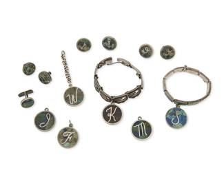 305
A Group Of Los Castillo Silver And Hardstone Inlay Jewelry
Circa 1950-1965; Taxco, Mexico
Each stamped: Los Castillo; further variously stamped: Taxco / Sterling / / 925 / Made in Mexico / [Eagle 15] / [Eagle 1] / Silver / Mosaico Azteca / 133 / 114 / 232 / 122
Ten Mosaico Azteca works in sterling silver with green and blue hardstone inlay comprising two link bracelets, each with a round monogrammed charm in K and S (6.5" L x 1.75" H; 6.375" L x 1.625" H), as well as three pairs of round earclips with monogram letters and Zodiac symbols (Largest: 0.75" Dia.; Smallest: 0.625" Dia.), four round charms with various monogram letters J, W, F, M, one with an attached chain (Each: 1.125" Dia.), and a single cufflink with monogram letter N (0.625" Dia.), 13 pieces
159.7 grams gross
Estimate: $400 - $600