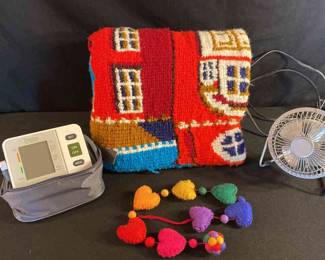 Afghan Blanket, Blood Pressure Cuff, Electric Fan, And A Hanging Heart Decoration