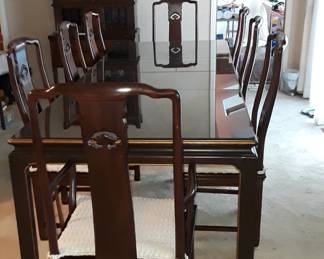 Magnificent 1980s Henredon chinoiserie 9-piece dining set for large gatherings. Table measures 42"W x 70"L. Add one or two 20" leaves to extend table to 90" or 110" long. The table has four scenes of Chinese riverside living and each leaf adds two more scenes against a background of deepest brown wood. Eight Henredon Ming chairs include two armchairs and six side chairs. The mahogany chairs have rattan seats topped with custom upholstered cushions. Contact us for a private showing before the estate sale on Friday. $2200