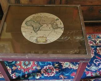 small table with inset map under glass