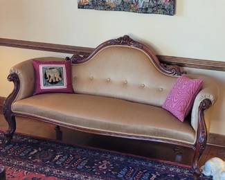 Carved wood and upholstered camelback settee purchased in Scotland in the early 1960's and dates back to the Victorian era