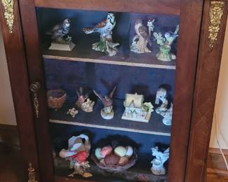 small glass front curio cabinet with brass details, photos of birds follow