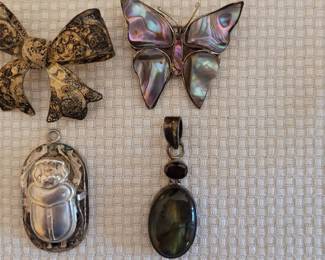 #76 filigree bow pin, #77 Egyptian scarab pendant purchased in Egypt, #78 .925 pendant w/opal & garnet, #79 .925 butterfly Mexico