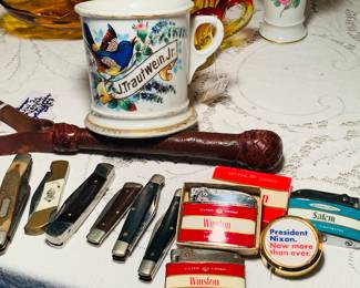 WW 2 issued leather "night stick", pocket knives, vintage lighters, a Nixon tape measure and an early Limoges shaving mug