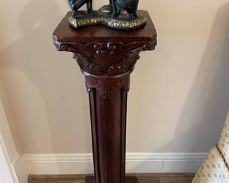 One of a pair of mahogany column pedestals with dog sculpture 