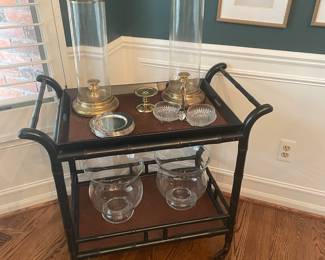 Another view of the bar cart with brass hurricane candles and large glass pillar holders