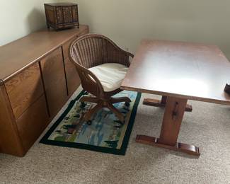 Tressel table, wicker swivel office chair, and credenza