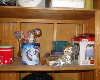 Holiday tins, plastic storage containers, and holiday baking pan, along with an electric kettle