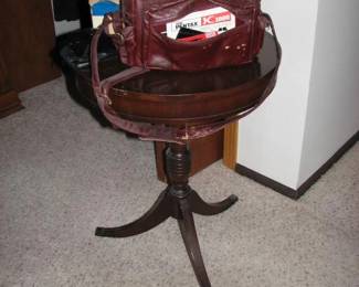 3 footed round table with vintage cameras on top