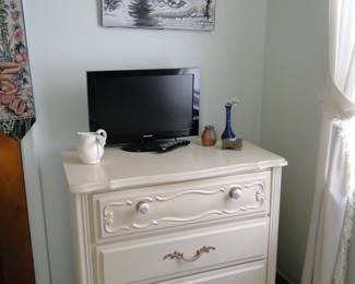 White dresser with three drawers, and small TV