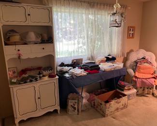 In another room, you'll find the wicker chair, the table of fabric, and the tall cabinet.