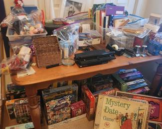 Pine farmhouse table covered with office supplies, craft supplies, puzzles and games