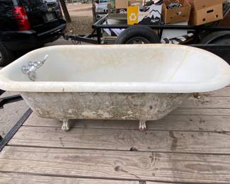 Antique clawfoot bathtub with handles, drain and original stainless shower curtain surround.