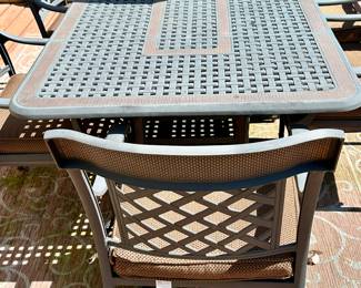 Take a look at this very unique Patio Table and Chairs.  Made from Aluminum Cast with Lattice Woven Style in the Chairs and Table.  The design features a Copper Element to the Chairs, Table and Umbrella Stand. The Table is 72" Long and 41" Wide.  There are 2 Swivel Rockers and 4 Dining Chairs. The cushions are in great condition by Sunbrella and  the Umbrella is from Garden Treasures and in Rectangular in shape . Purchased from Great Escape.