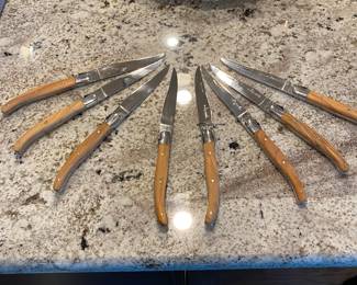 K61 - $250. Set of 8 Olive Wood Handles Laguiole Knives. Like New Condition. 