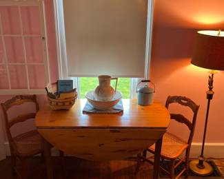 Primitive drop leaf table, vintage bowl and pitcher, vintage cookbooks, enamel pan with bale handle and press back chairs.