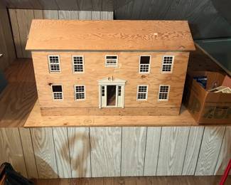 Homemade built dollhouse and boxes of doll house furniture.