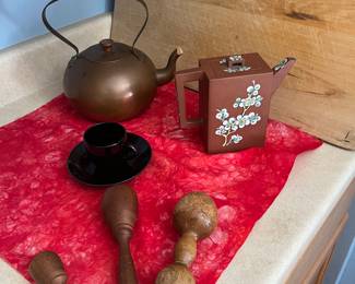 Copper and ceramic tea pots and antique wooden utensils.
