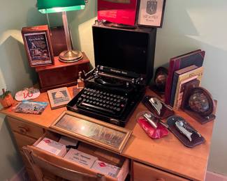 Antique Remington rand typewriter, bookends, desk lamp, ship in a bottle, World War II memorabilia, wooden box and desk and chair.