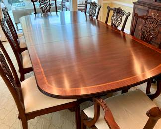 Classic mohagany double pedestal dining table with beautiful claw feet and 10 intricately carved, upholstered chairs, 2 of which are arm chairs. Family has set a reserve at $15,000, although reasonable offers may be considered; table: 72x46x29 (without 24" leaf); arm chairs: 24x20x38; side chairs: 23x20x38