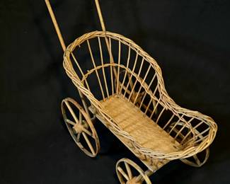 Antique child's doll buggy in wicker and wood