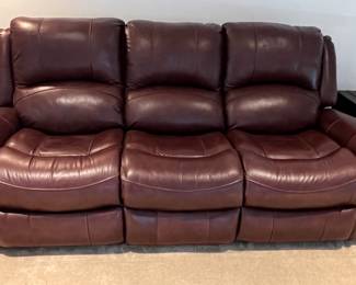 Wine colored faux leather reclining sofa and loveseat