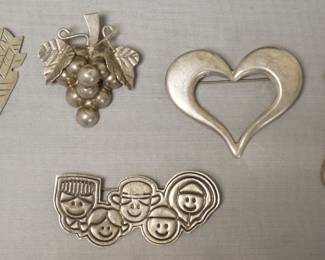 1252	MEXICO STERLING SILVER PIN ASSORTMENT INCLUDING GRAPE CLUSTER MARKED GL-SL AND THE FACES MARKED SAVE THE CHILDREN. 1.7 TOZ

