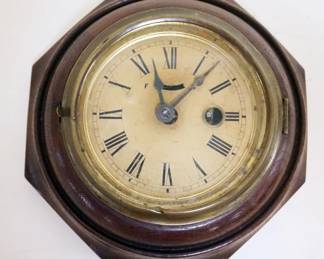 1029	ANTIQUE MINIATURE WALL CLOCK IN OCTAGON WALNUT CASE, APPROXIMATELY 7 IN
