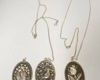 1243	3 INTERNATIONAL STERLING PENDANTS, 2 WITH CHAINS. PENDANT APPROXIMATELY 2 1/2 IN X1 1/2 IN W, 1.54 TOZ. CHAINS NOT MARKED
