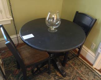 Old wooden table and two chairs, painted a dark green. 