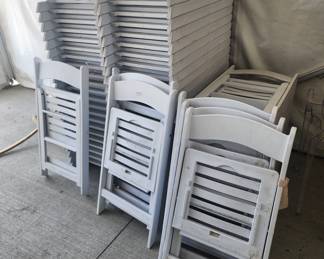 Numerous white folding event chairs