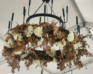 Large chain-mounted electric chandelier with candlestick lighting, currently hanging in the amazing event space pavilion!