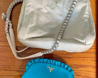 Prada cream nylon handbag and blue Prada cosmetic bag.