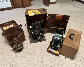 A brass Stolmann transit with case, another transit with case (I will get the name for you soon) and a slide projector.