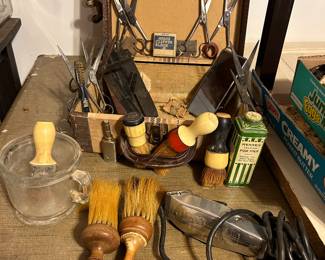 A Barbers traveling tools of the trade used in making "house calls". Note the numerous combs and scissors along with an Andie Clipper razor & an extra blade, lather up brushes with wiping down brushes... AND don't over look the adorable suitcase holding everything!!