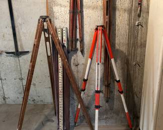 4 surveyors tripods, measuring tool and (upper right - surveyor stakes.
