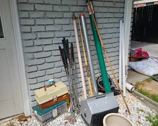 Golf clubs, fishing poles and tackle. 