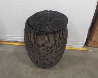 Barrel shaped wicker hamper with handles and a lid. 20 inches tall