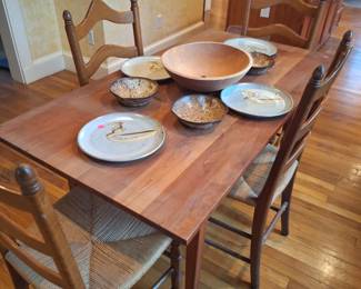Cherry dining table and five ladderback chairs with rush seats