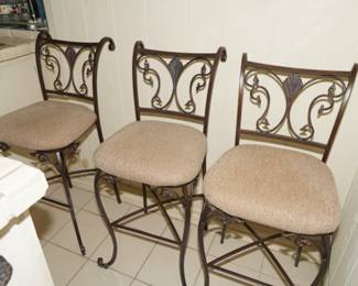 There are five of these upholstered wrought iron bar chairs available