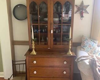 Just a very sweet cupboard in a size that will fit in most any space.  It is two pieces with glass panels.  Next  photo shows inside of upper case a nice interior with three drawers.