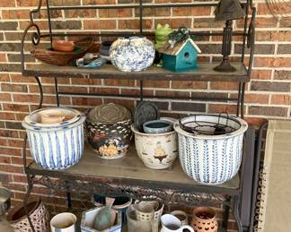 Black bakers rack with glass shelves and assorted pots