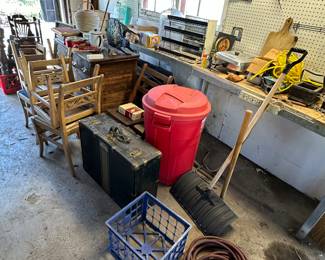 Lots of antique chairs, etc., in the garage. Glass shelves, air hose. Military suitcase
