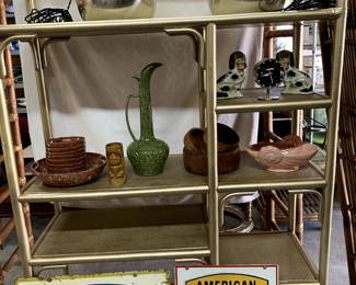 Double-sided vintage metal signs, various vintage decor items, rattan/wicker shelving unit.