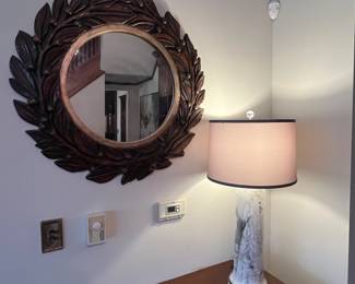 carved wood round mirror and contemporary lamp