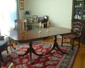 1940's Mahogany table with two leaves. Excellent condition. Two matching ribbon back captain chairs from the original set. 