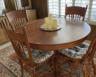 Antique oak dining table with four chairs.  Includes 2 leaf extensions.  