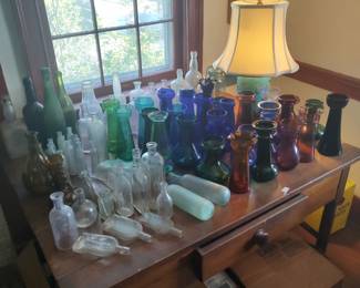 Bottles, hyacinth vases, and table lamp shown on the Sheraton walnut farm table, circa 1830.