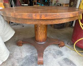 Round oak pedestal table on wheels
